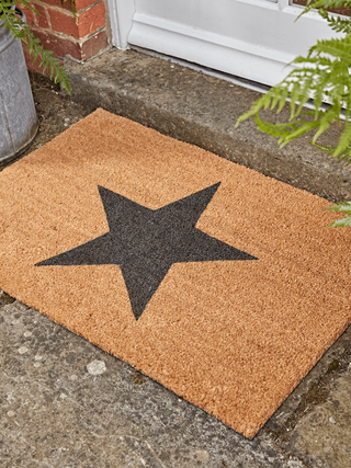 door mat with black star in front of a house