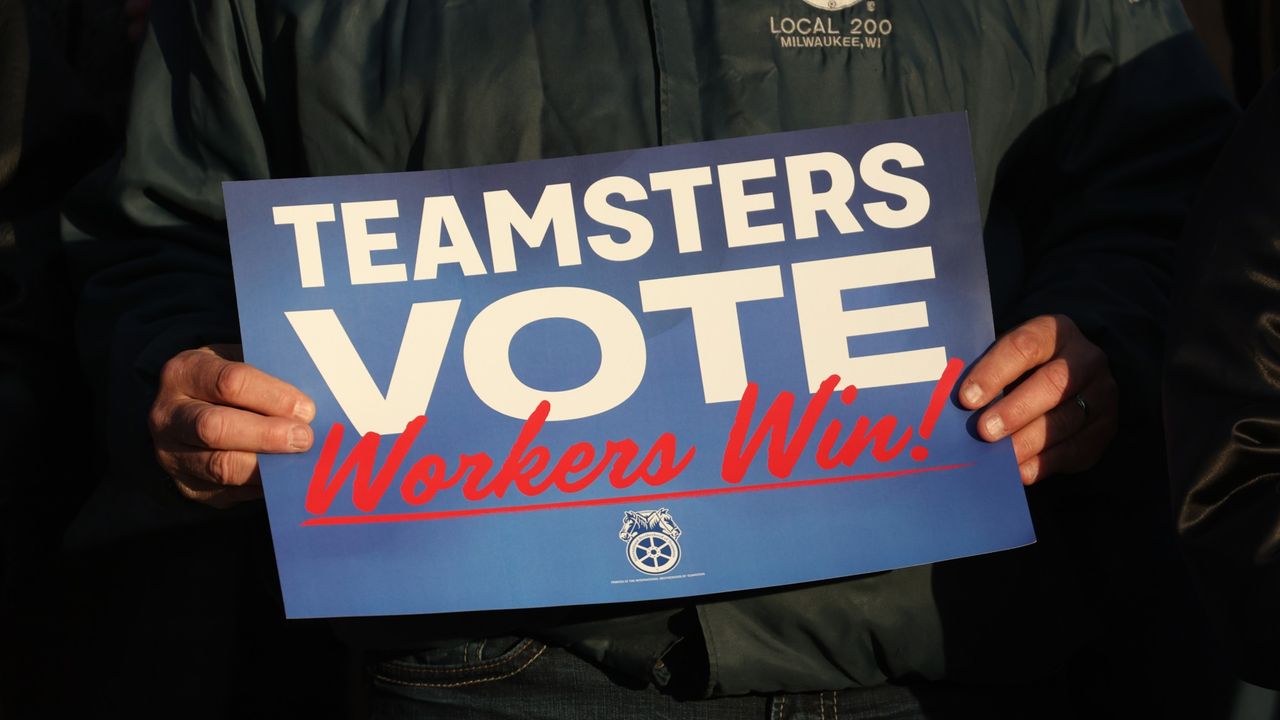 A man holds a Teamsters voting sign during a rally in Madison, Wisconsin, in 2022.