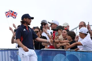 Tommy Fleetwood high fives the crowd