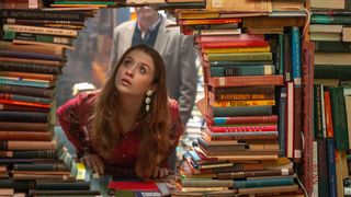 A girl looks through a pile of books