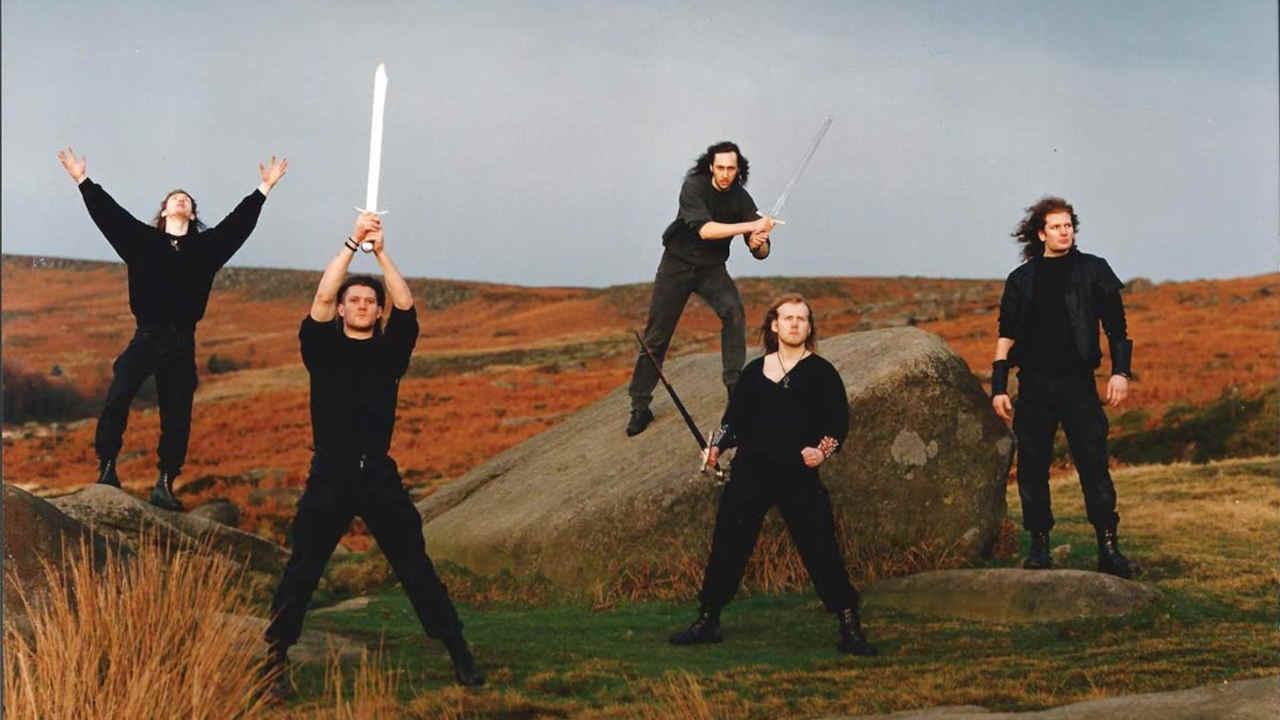 Bal-Sagoth posing for a photograph on moorland with a sword in the air