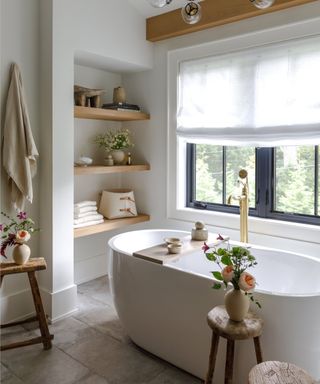 A bathroom with a freestanding tub and large windows