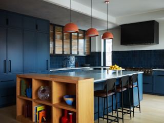 A kitchen with pendant lights above the island