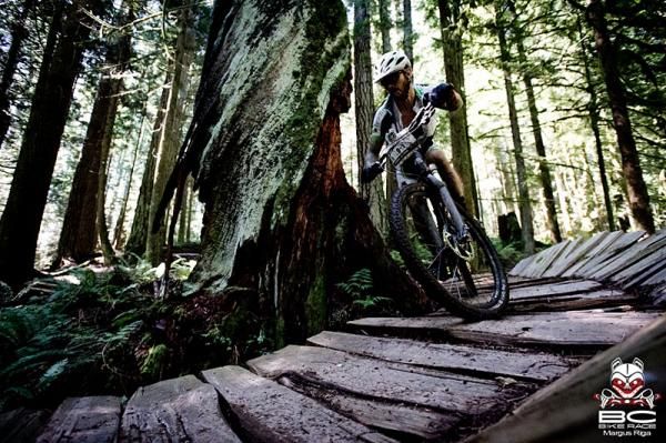 Caf&eacute; Express rider Scott Edmunds hugs a tree while riding one of the many built sections of wooden trail.