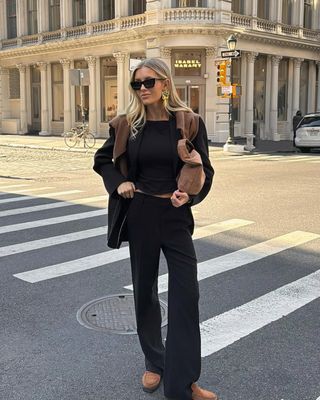 woman wearing all black outfit with tan loafers