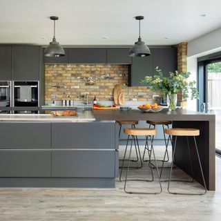 kitchen with wooden flooring and grey cabinets and wooden top stool