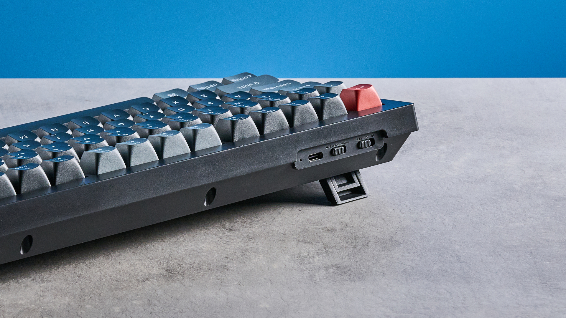 Keychron V3 Ultra 8K photographed on a grey table top in front of a blue background