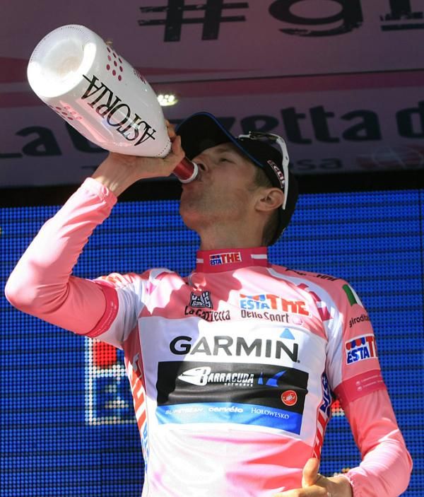 Maglia rosa wearer Ryder Hesjedal takes a swig of champagne on the podium.