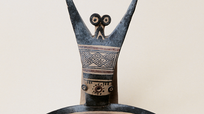 close-up of a human figurine with geometric decoration