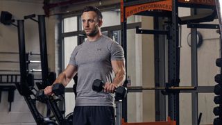 Man performs lowering portion of the Zottman curl using dumbbells