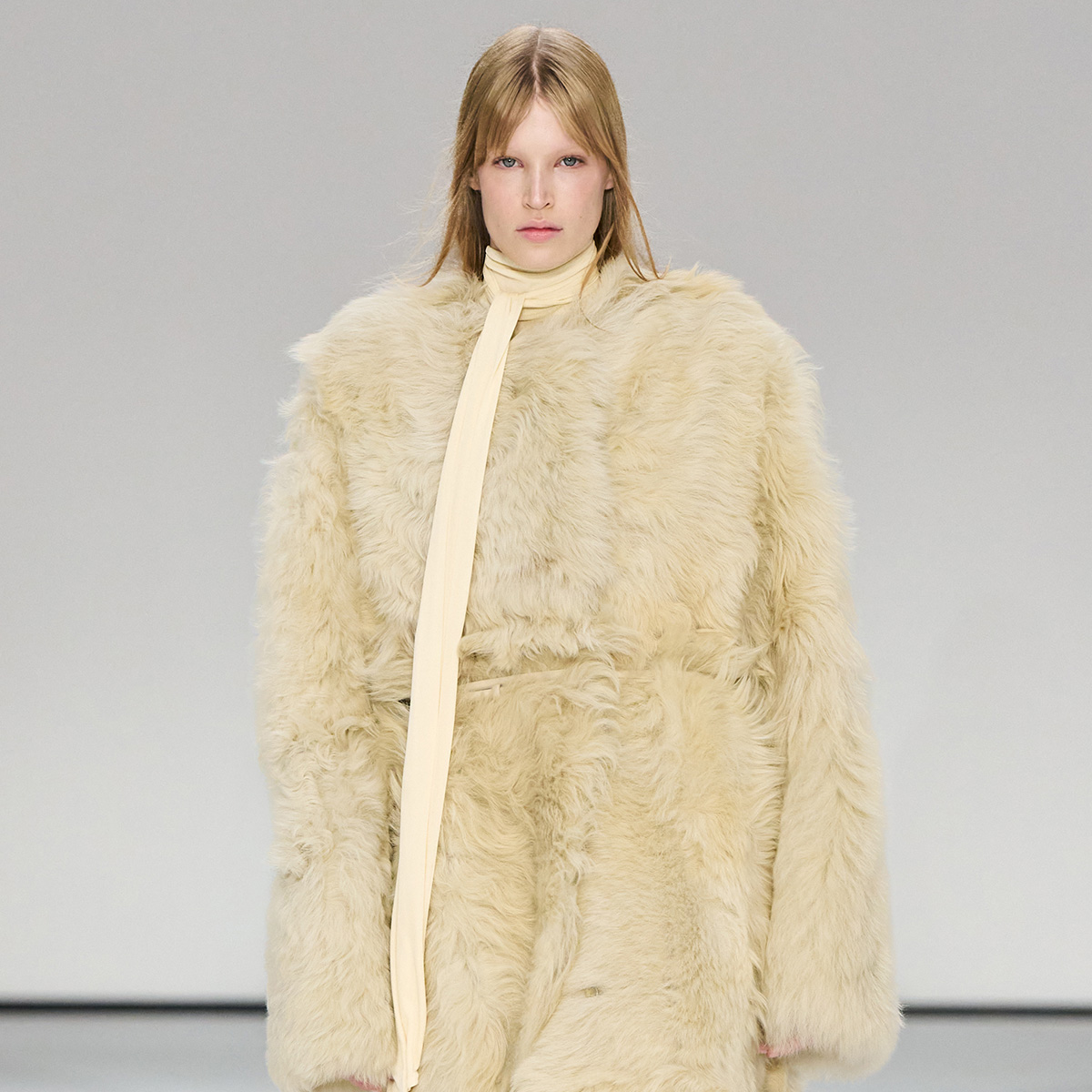 A model wears a fur coat and ivory neck piece.