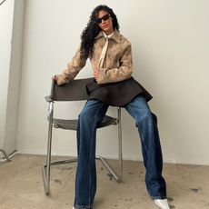 Sami wears a tie, a leather jacket, black skirt, blue jeans, and white pumps.