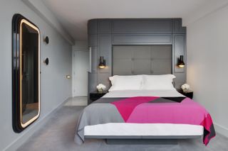 hotel bedroom with grey and fuchsia color scheme