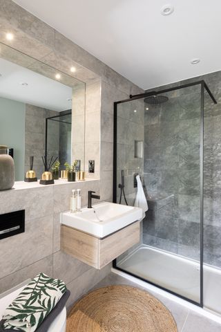 A modern bathroom with stone tiles and black brassware