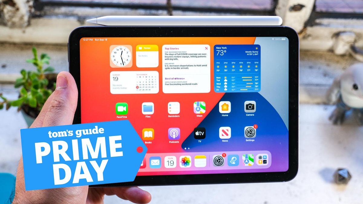 The iPad mini 6 in hand, a Tom&#039;s Guide Prime Day deal icon is in the bottom left corner