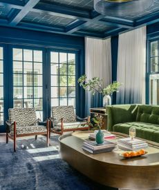 blue living room with twin armchairs and green sofa