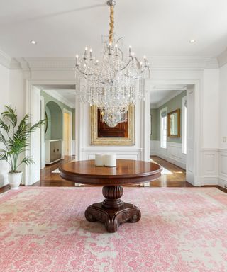 Grand entryway with a chandelier and pink carpet