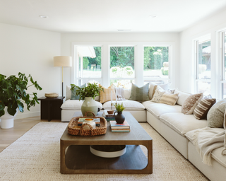 White sectional in large, airy living room with fiddle leaf fig and wooden coffee table