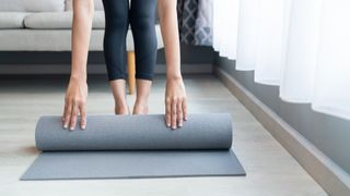 woman rolling out yoga mat