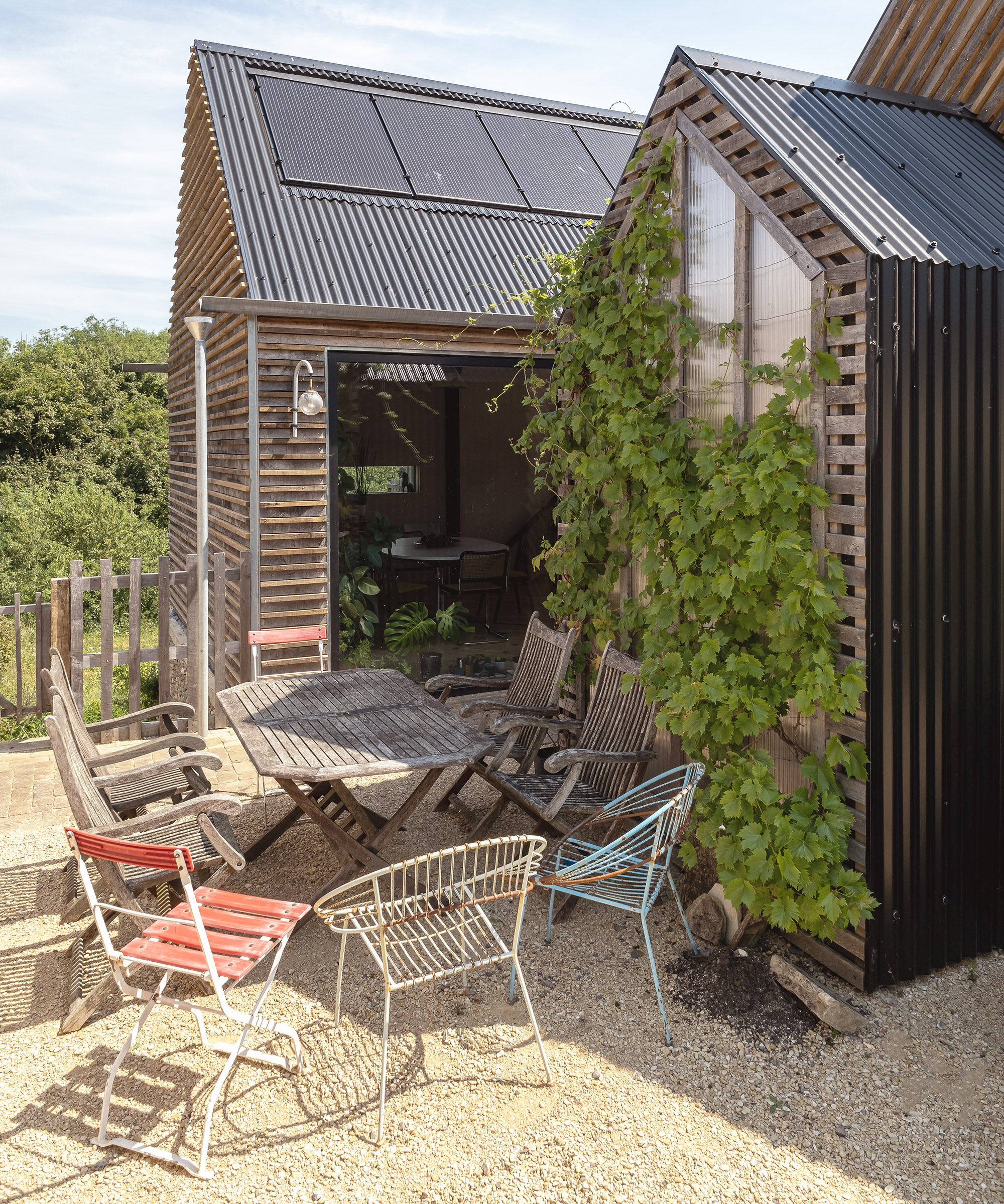 A gravel patio area in front of a self build with garden furniture