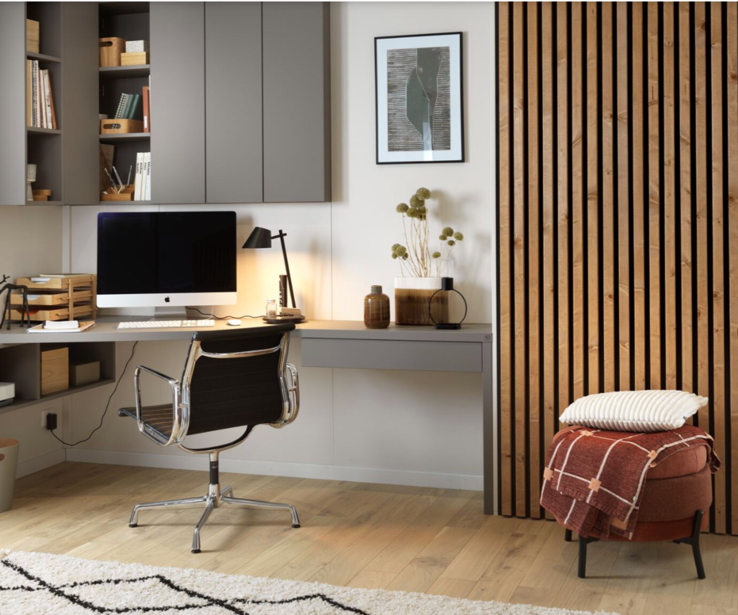 A modern home office with a corner desk and slatted wall panels