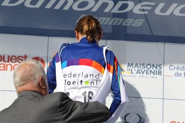 Annemiek Van Vleuten (Nederland Bloeit) is helped into the World Cup winner's jersey