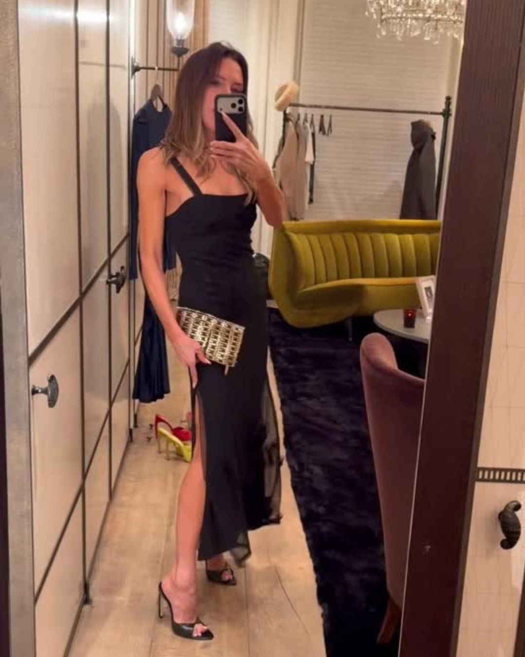 Victoria Beckham wears black peep-toe heels with a black dress.