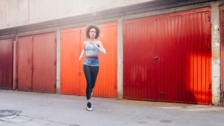 Athlete Running Outdoors next to a Row of Garages