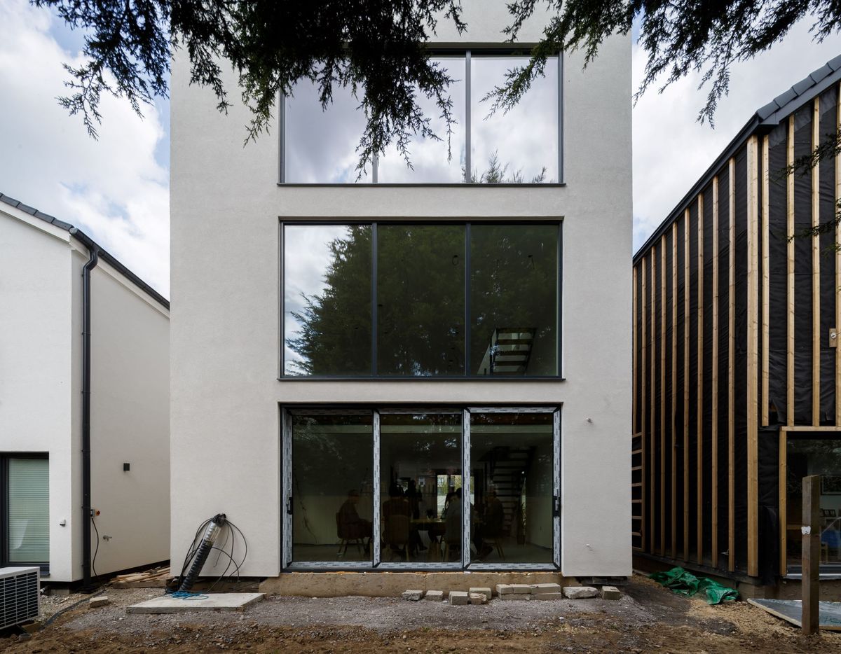 The rear of the property shows bifold doors to lead to the garden and large windows on each floor of the three-storey property