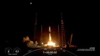 a black and white spacex falcon 9 rocket launches at night.