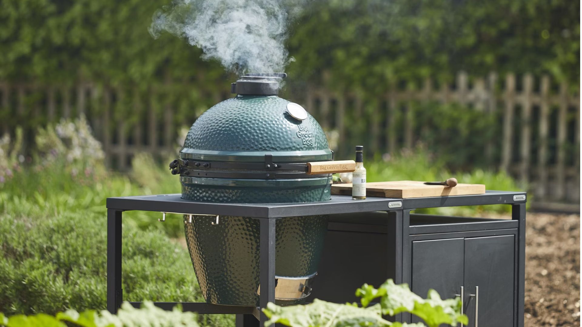 A Big Green Egg with smoke coming out the top