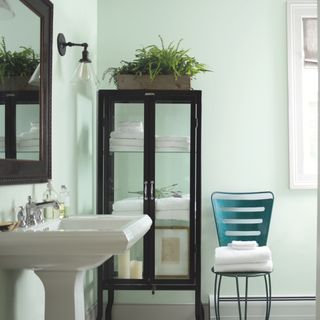bathroom with white wall and chair and mirror and washbasin