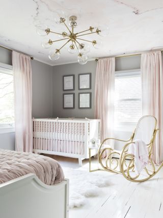 pink and gray baby girl nursery with gold accents , white flooring, gold and clear glass pendant
