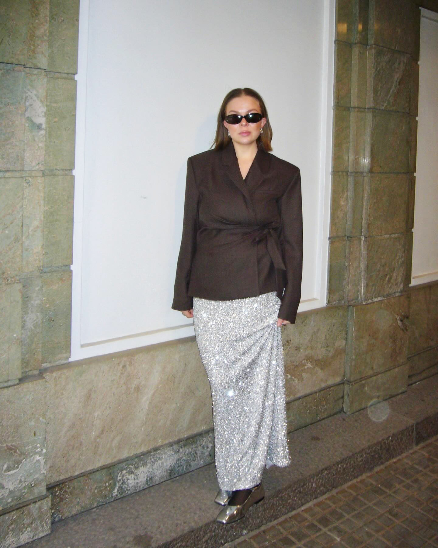 Dina Hansen wearing a brown blazer, a silver sequin skirt, and silver flats