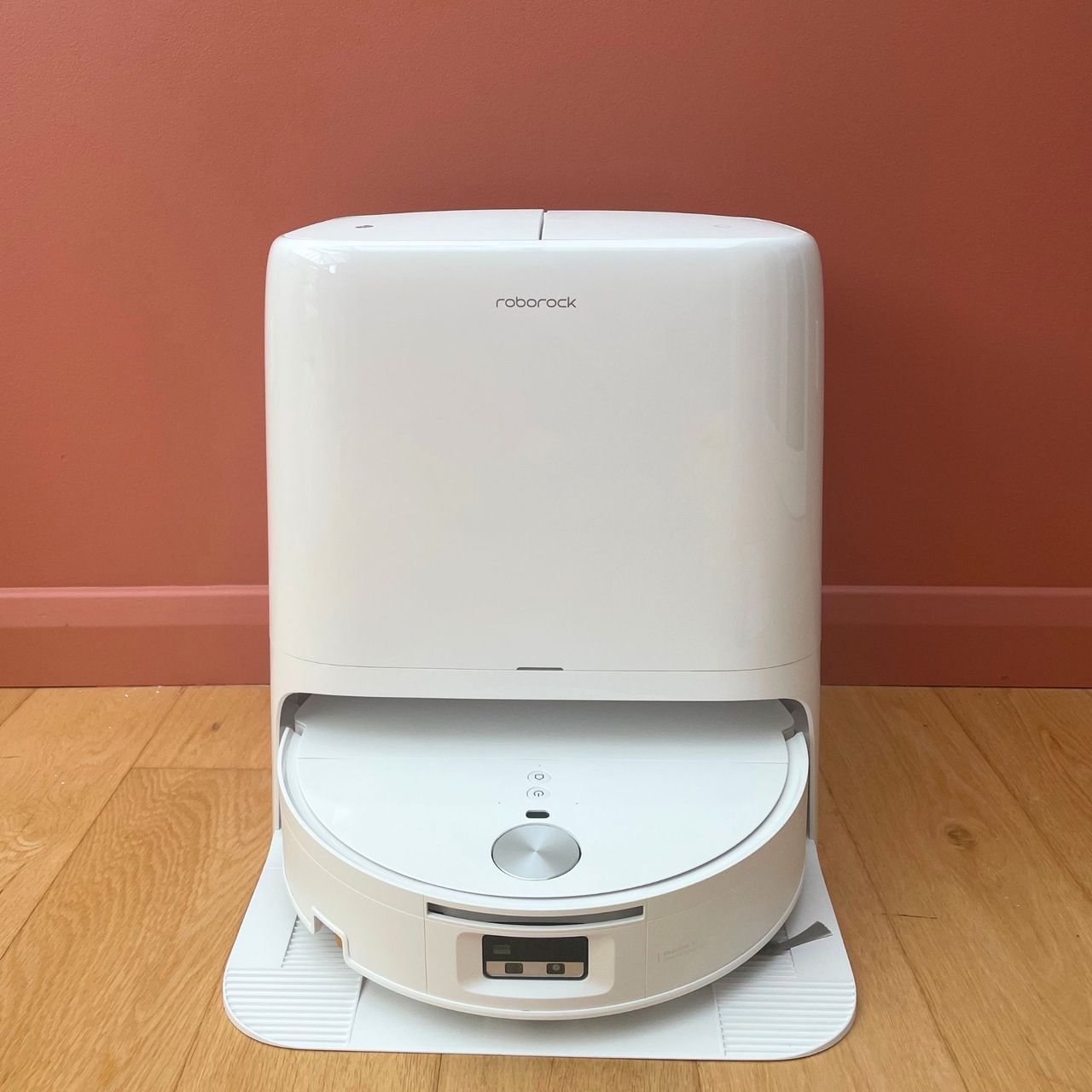 Roborock Qrevo Edge 2 Flow Robot Vacuum sitting on wooden floor in front of a pink wall