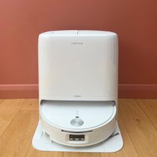 Roborock Qrevo Edge 2 Flow Robot Vacuum sitting on wooden floor in front of a pink wall