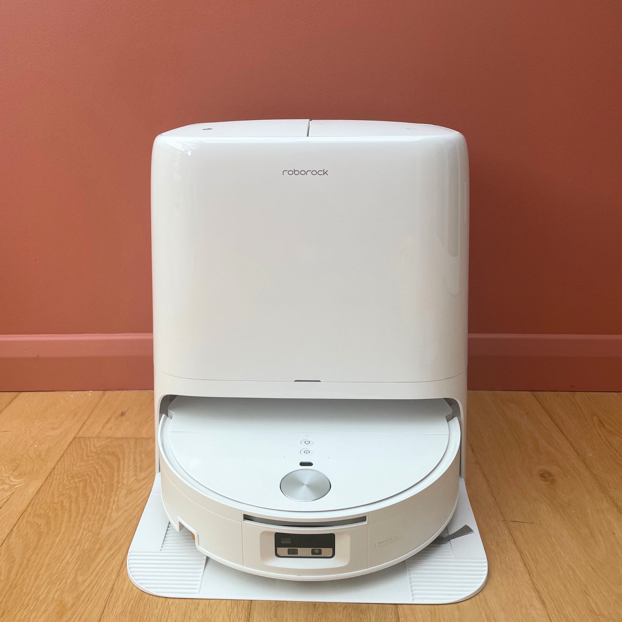 Roborock Qrevo Edge 2 Flow Robot Vacuum sitting on wooden floor in front of a pink wall