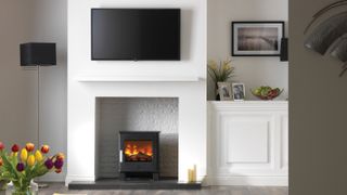electric stove in white fire surround with wall-mounted tv