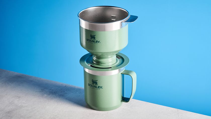 the stanley perfect brew pour over coffee maker in green, photographed with its companion travel mug and with the metal built in filter