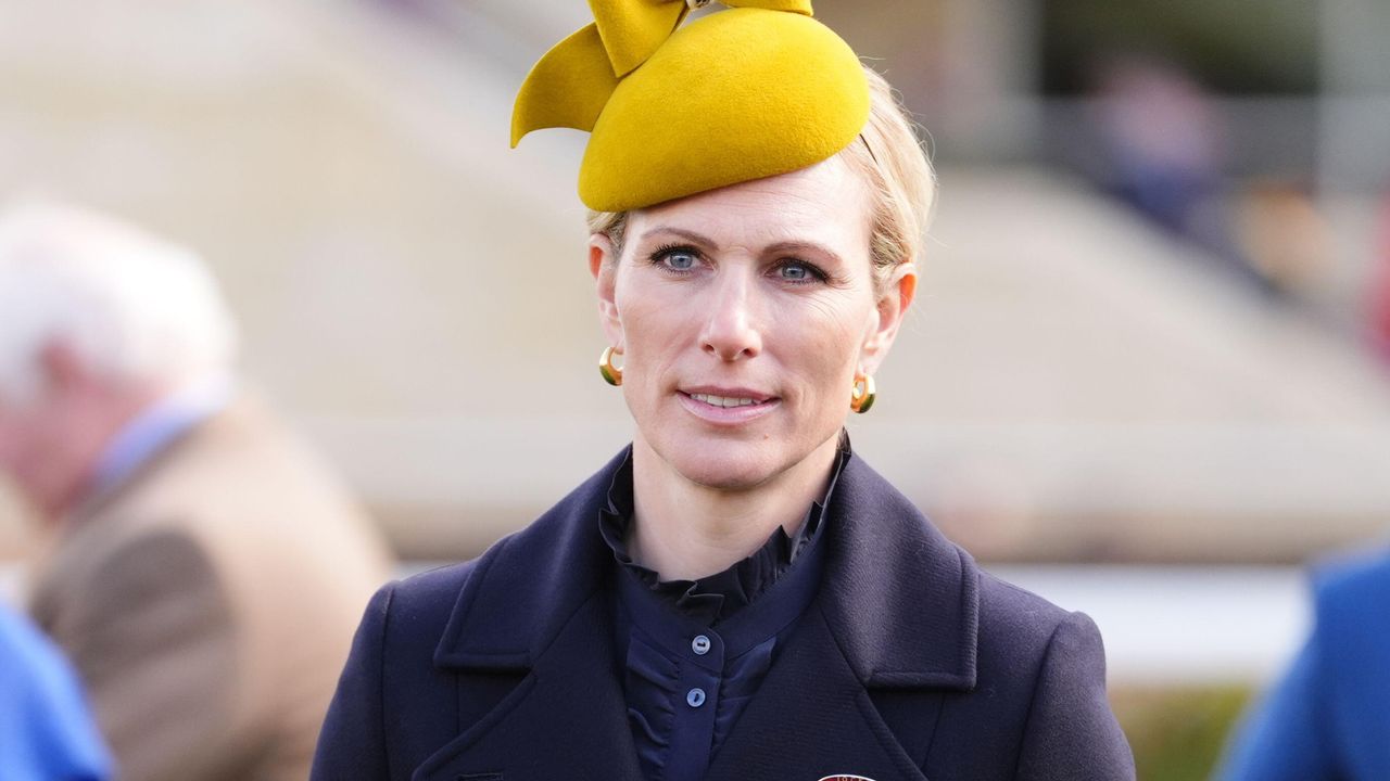 Zara Tindall, wearing a mustard yellow hat and navy outfit, on day one of the 2025 Cheltenham Festival at Cheltenham Racecourse