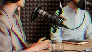 Two podcast hosts sat at a table, both are showing a glitch effect indicating that they are digital or virtual elements in the frame