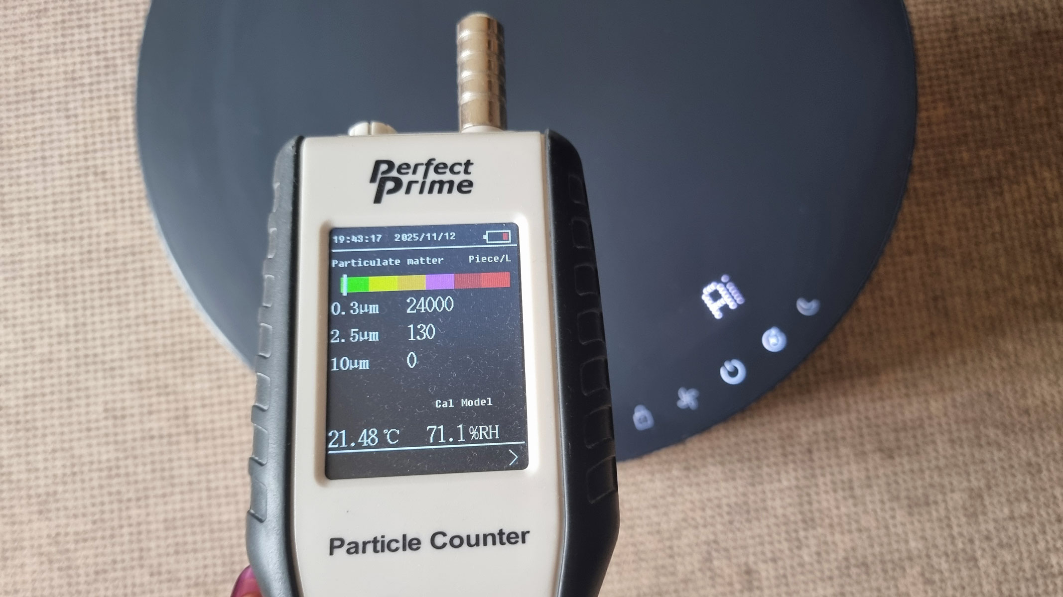 A close-up picture of our reviewer testing the Blueair Blue Signature air purifier using the Perfect Prime air particle monitor
