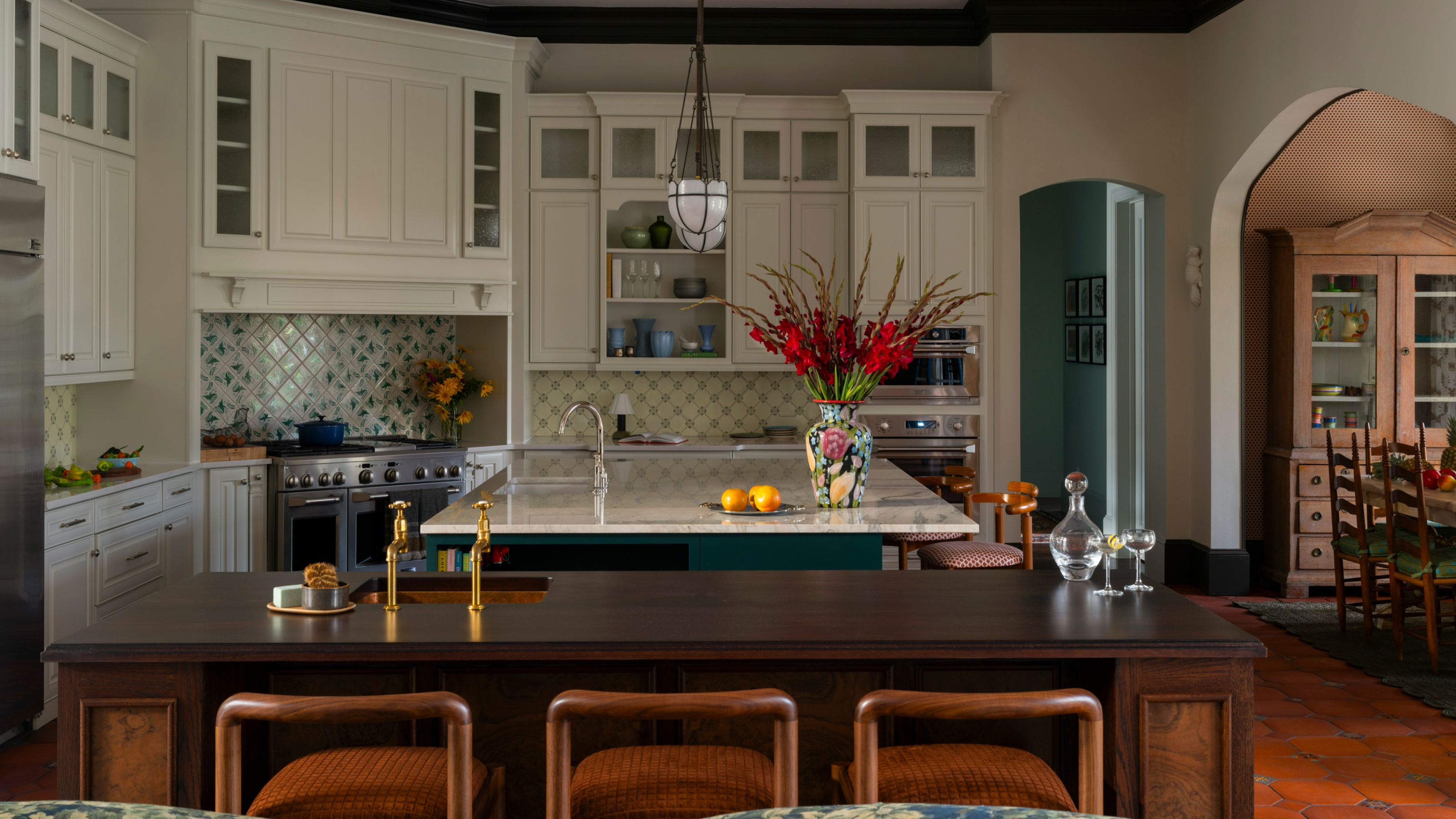 a large white kitchen in florida with a green island and a dark second wooden island with a sink inside