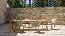 teak outdoor dining table and chairs on a patio