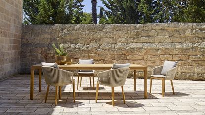 teak outdoor dining table and chairs on a patio