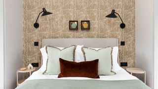 bedroom with patterned wallpaper and pale green bedding
