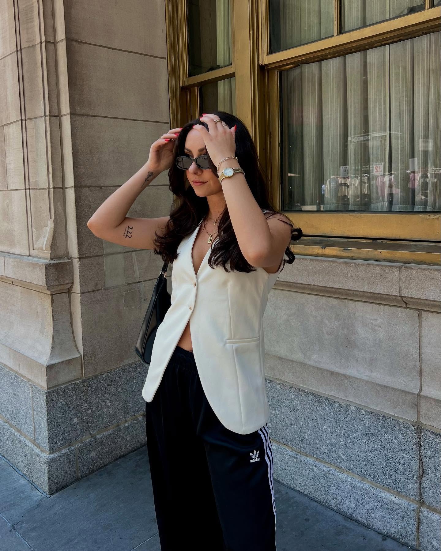 kendall wears white vest with black adidas track pants
