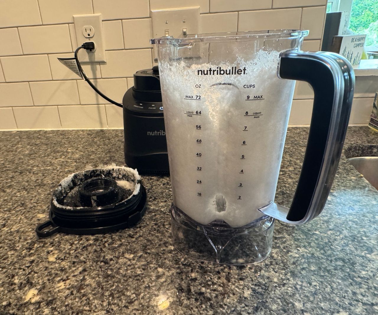 A side view of a blender pitcher filled with powdered ice.