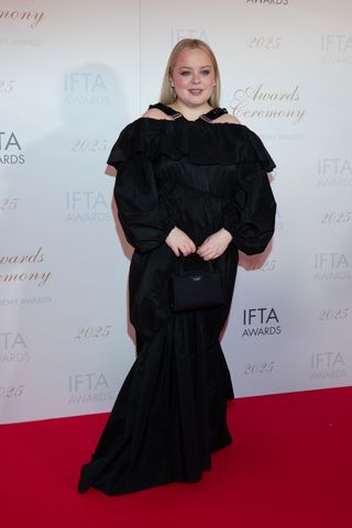 Nicola Coughlan attends the 2025 Irish Film and Television Academy Awards wearing a Kate Spade Sam Bag