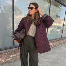 Fashion influencer Jen Azoulay wearing a chic fall outfit featuring a burgundy barn jacket and bag on the streets of New York City.